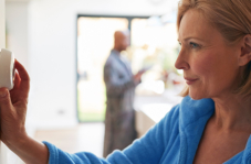 woman adjusting thermostat